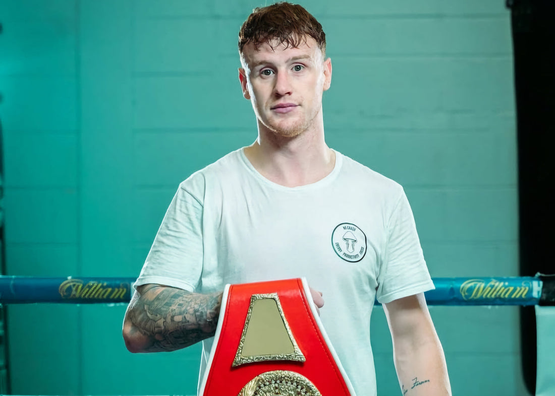 Swansea boxer Ben Crocker holding a championship belt in the gym